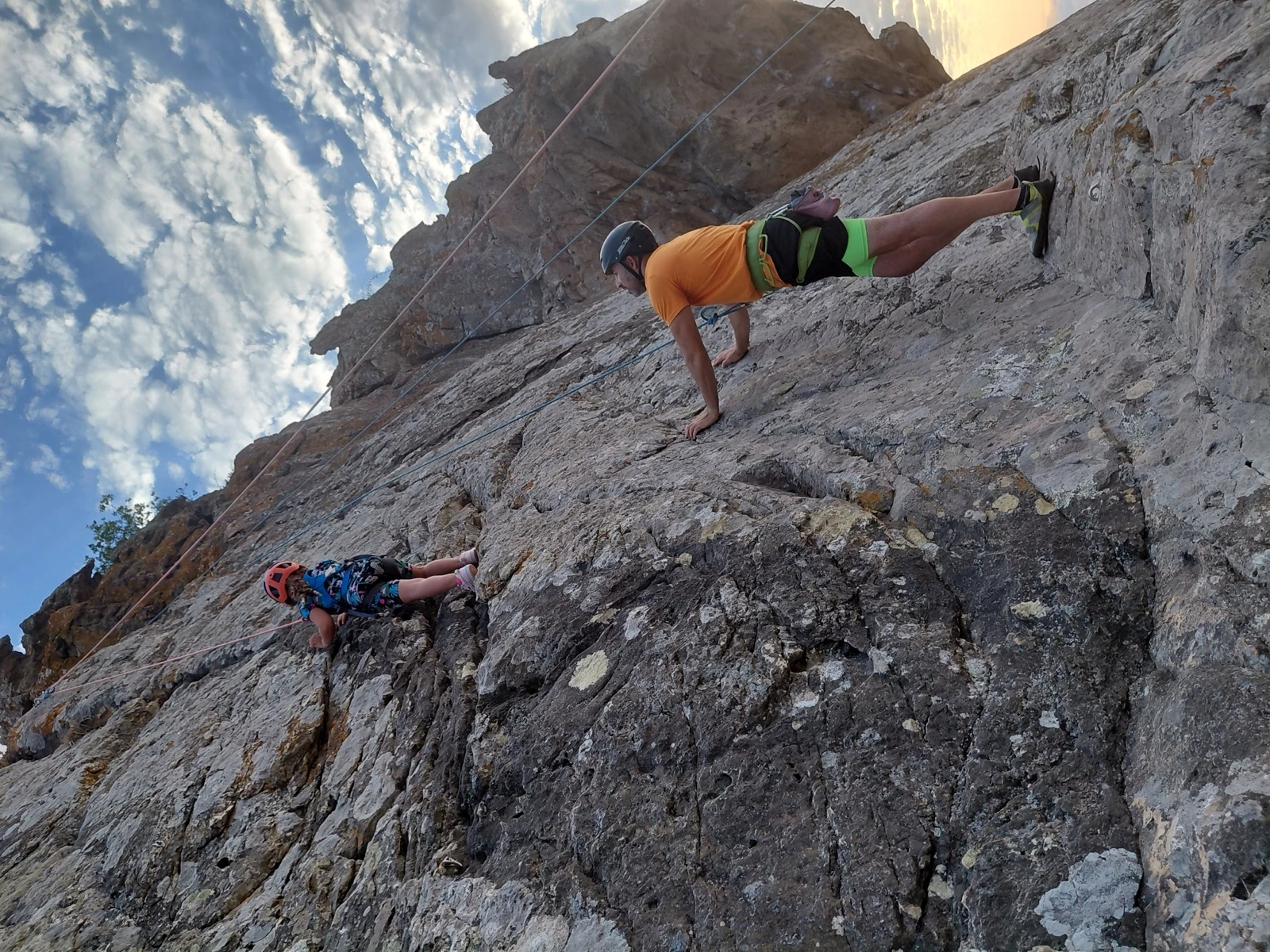 Young climber on a rock with an adult nearby in Cyprus
